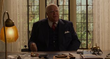 Movie still from “The Big Lebowski” (1998), directed by Ethan Coen – An older man sitting at a table in front of a window; Medium shot, Over the shoulder angle