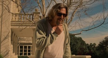 Movie still from “The Big Lebowski” (1998), directed by Ethan Coen – A man with long hair and a beard wearing sunglasses; Medium shot, Low angle