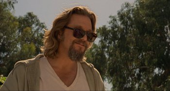 Movie still from “The Big Lebowski” (1998), directed by Ethan Coen – A person wearing sunglasses with trees in the background; Close Up shot, Low angle