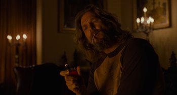 Movie still from “The Big Lebowski” (1998), directed by Ethan Coen – A man with long hair is smoking a cigarette; Medium shot, Over the shoulder angle