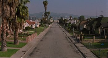 Movie still from “The Big Lebowski” (1998), directed by Ethan Coen – An empty street with palm trees in the background; Extreme Wide shot, High angle