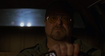 Movie still from “The Big Lebowski” (1998), directed by Ethan Coen – A person wearing glasses and a hat; Close Up shot, Low angle