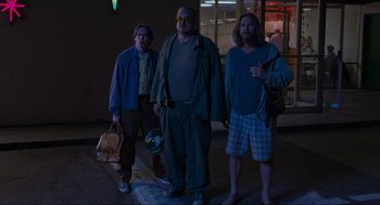 Movie still from “The Big Lebowski” (1998), directed by Ethan Coen – A group of men standing next to each other on a sidewalk; Wide shot, Low angle