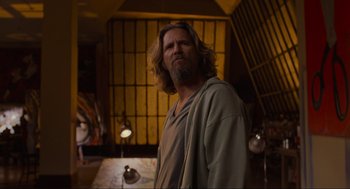 Movie still from “The Big Lebowski” (1998), directed by Ethan Coen – A man with long hair and a beard standing in a room; Medium shot, Over the shoulder angle