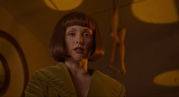 Movie still from “The Big Lebowski” (1998), directed by Ethan Coen – A woman with brown hair wearing a yellow jacket; Close Up shot, Low angle