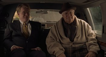 Movie still from “The Big Lebowski” (1998), directed by Ethan Coen – Two men sitting in the back seat of a car; Medium shot, Over the shoulder angle