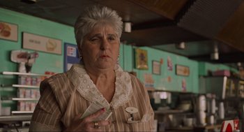 Movie still from “The Big Lebowski” (1998), directed by Ethan Coen – An older woman holding a roll of toilet paper; Close Up shot, Low angle