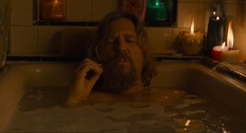 Movie still from “The Big Lebowski” (1998), directed by Ethan Coen – A man with long hair and a goatee is in a bath tub; Medium shot, Low angle