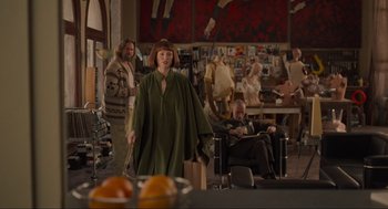 Movie still from “The Big Lebowski” (1998), directed by Ethan Coen – A woman in a green dress holding a stick; Wide shot, Over the shoulder angle