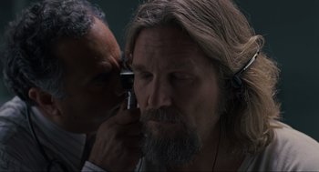 Movie still from “The Big Lebowski” (1998), directed by Ethan Coen – A man with long hair and a long beard is listening to music with an older man; Close Up shot, Over the shoulder angle