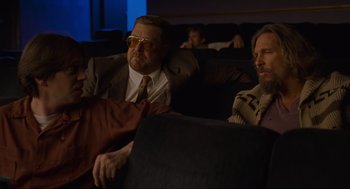 Movie still from “The Big Lebowski” (1998), directed by Ethan Coen – A group of men sitting on a couch in front of a window; Medium shot, Low angle
