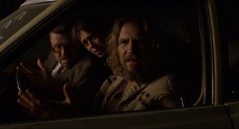 Movie still from “The Big Lebowski” (1998), directed by Ethan Coen – A group of people sitting in the back of a car; Medium shot, Low angle