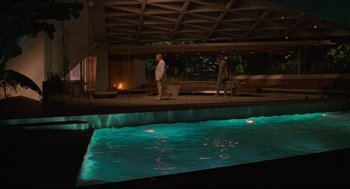 Movie still from “The Big Lebowski” (1998), directed by Ethan Coen – A man and a woman standing next to an indoor swimming pool; Extreme Wide shot, High angle