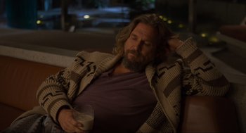 Movie still from “The Big Lebowski” (1998), directed by Ethan Coen – A man with a beard is holding a drink; Medium shot, Over the shoulder angle