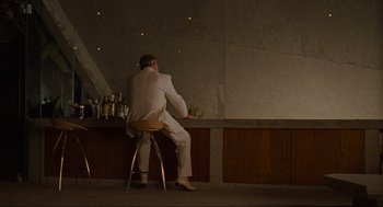 Movie still from “The Big Lebowski” (1998), directed by Ethan Coen – A man sitting at a bar talking on the phone; Wide shot, Low angle