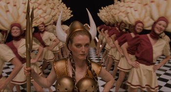 Movie still from “The Big Lebowski” (1998), directed by Ethan Coen – A woman in a gold costume with horns on her head; Medium shot, High angle