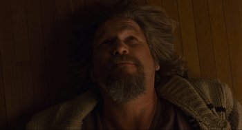 Movie still from “The Big Lebowski” (1998), directed by Ethan Coen – A man with long hair and a beard laying on the ground; Close Up shot, Low angle