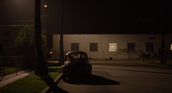 Movie still from “The Big Lebowski” (1998), directed by Ethan Coen – A car parked on the side of the road at night; Extreme Wide shot, High angle