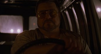 Movie still from “The Big Lebowski” (1998), directed by Ethan Coen – A person driving a car at night; Close Up shot, Low angle