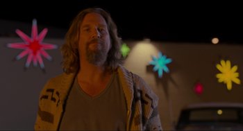 Movie still from “The Big Lebowski” (1998), directed by Ethan Coen – A man with long hair and a beard standing in a room; Medium shot, Low angle