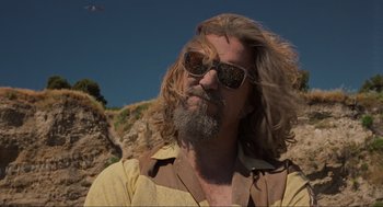 Movie still from “The Big Lebowski” (1998), directed by Ethan Coen – A person with long hair wearing sunglasses; Close Up shot, Low angle