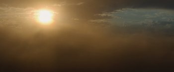 Movie still from “The Biggest Little Farm: The Return” (2022), directed by John Chester – The sun is shining through the clouds on a cloudy day; Extreme Wide shot, Low angle