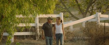 Movie still from “The Biggest Little Farm: The Return” (2022), directed by John Chester – A man and a woman standing next to each other in a field; Wide shot, High angle