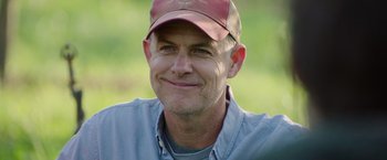 Movie still from “The Biggest Little Farm: The Return” (2022), directed by John Chester – A person wearing a hat; Close Up shot, Over the shoulder angle