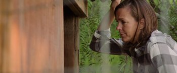 Movie still from “The Biggest Little Farm: The Return” (2022), directed by John Chester – A woman holding a skateboard up to her head; Close Up shot, Low angle