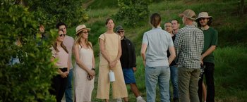 Movie still from “The Biggest Little Farm: The Return” (2022), directed by John Chester – A group of people standing in the grass; Wide shot, Over the shoulder angle