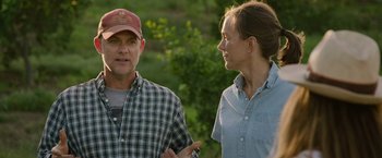 Movie still from “The Biggest Little Farm: The Return” (2022), directed by John Chester – A man and a woman are standing outside talking; Medium shot, Over the shoulder angle
