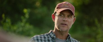 Movie still from “The Biggest Little Farm: The Return” (2022), directed by John Chester – A person wearing a hat; Close Up shot, Over the shoulder angle