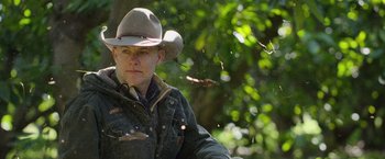 Movie still from “The Biggest Little Farm: The Return” (2022), directed by John Chester – A man wearing a cowboy hat in the woods; Close Up shot, Low angle