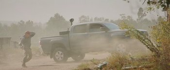 Movie still from “The Biggest Little Farm: The Return” (2022), directed by John Chester – A truck driving down a dirt road in the fog; Wide shot, Low angle