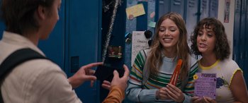 Movie still from “The Binge” (2020), directed by Jeremy Garelick – A person taking a picture of a woman with a phone; Medium shot, Over the shoulder angle