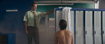 Movie still from “The Binge” (2020), directed by Jeremy Garelick – A man standing in front of a man in a room; Medium shot, Low angle