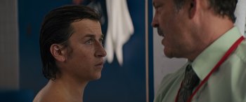 Movie still from “The Binge” (2020), directed by Jeremy Garelick – A man standing next to another man in front of a wall; Close Up shot, Over the shoulder angle