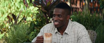Movie still from “The Binge” (2020), directed by Jeremy Garelick – A man sitting outside with a drink in his hand; Close Up shot, High angle