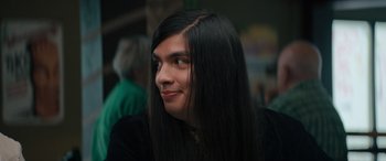 Movie still from “The Binge” (2020), directed by Jeremy Garelick – A man with long black hair looking to his left; Close Up shot, Over the shoulder angle