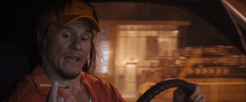 Movie still from “The Binge” (2020), directed by Jeremy Garelick – A man in a yellow hat sitting in the drivers seat of a car; Close Up shot, Over the shoulder angle