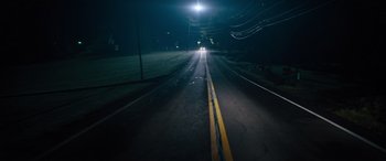 Movie still from “The Binge” (2020), directed by Jeremy Garelick – A car driving down a street at night; Extreme Wide shot, High angle