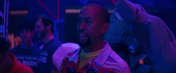 Movie still from “The Binge” (2020), directed by Jeremy Garelick – A person wearing a colorful shirt; Close Up shot, Over the shoulder angle