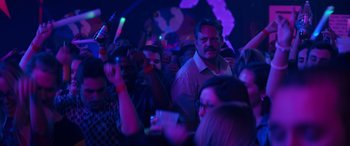 Movie still from “The Binge” (2020), directed by Jeremy Garelick – A group of people in a dark room at a party; Medium shot, Over the shoulder angle