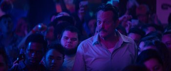 Movie still from “The Binge” (2020), directed by Jeremy Garelick – A group of people sitting in a dark room; Close Up shot, Low angle