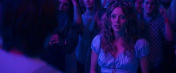 Movie still from “The Binge” (2020), directed by Jeremy Garelick – A group of people standing in a dark room; Medium shot, Over the shoulder angle