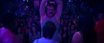 Movie still from “The Binge” (2020), directed by Jeremy Garelick – A man standing in front of a crowd of people at an event; Medium shot, Low angle