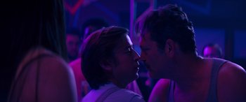 Movie still from “The Binge” (2020), directed by Jeremy Garelick – A man and a woman kissing in a room lit up with purple lights; Close Up shot, Over the shoulder angle