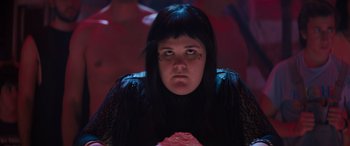 Movie still from “The Binge” (2020), directed by Jeremy Garelick – A woman in a black shirt is looking at the camera; Close Up shot, Low angle