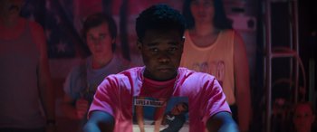 Movie still from “The Binge” (2020), directed by Jeremy Garelick – A man in a pink shirt is looking at the camera; Medium shot, Over the shoulder angle