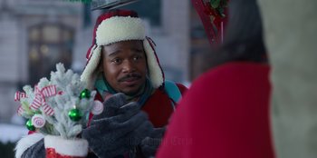 Movie still from “It's A Wonderful Binge” (2022), directed by Jordan VanDina – A man wearing a hat looking at his reflection in a mirror; Close Up shot, Over the shoulder angle